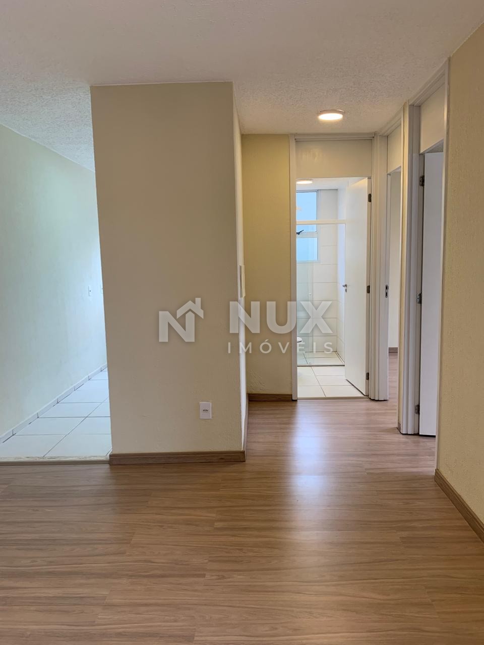 Corredor de acesso aos quartos e ao banheiro, com piso laminado
