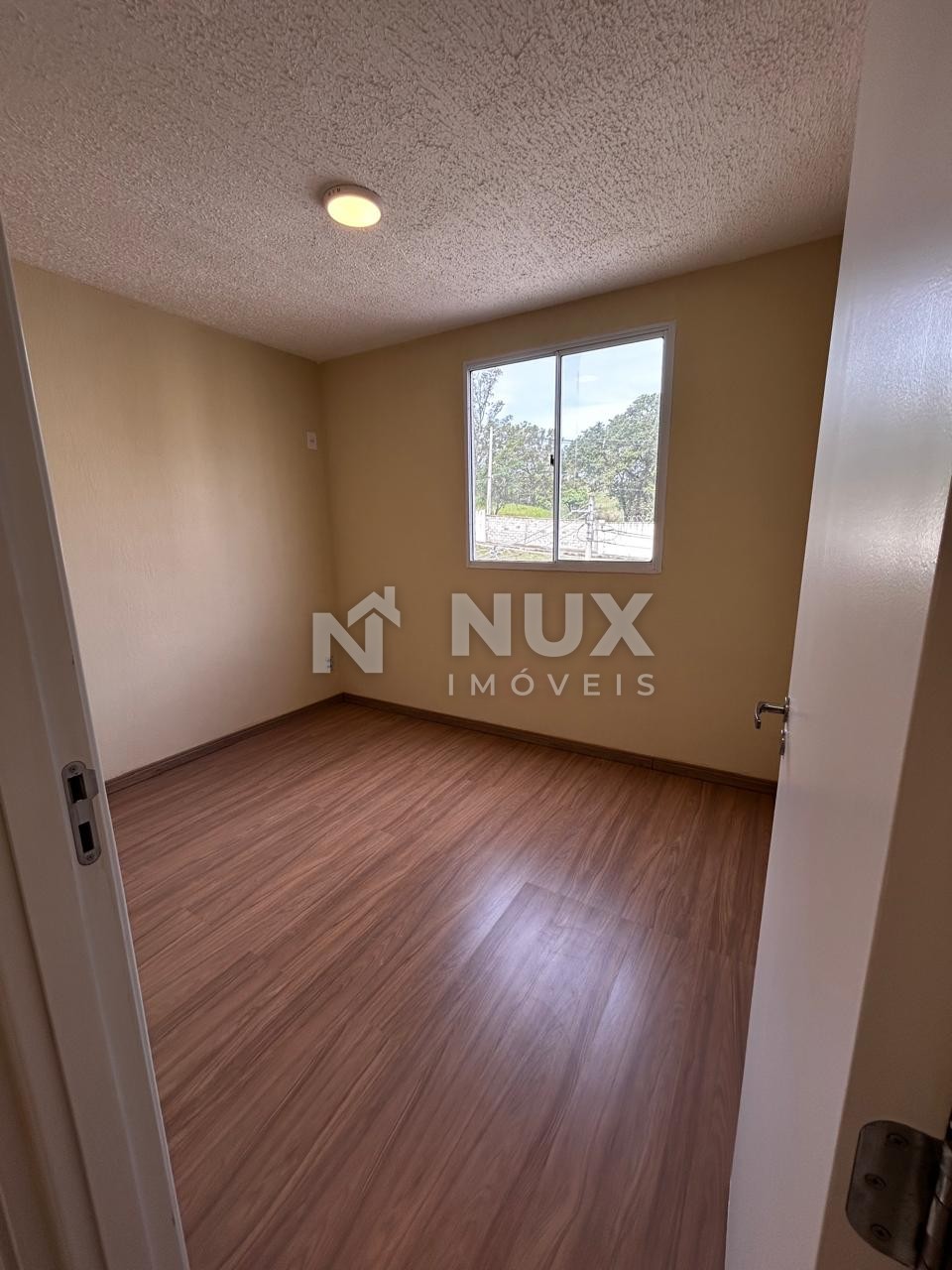 Quarto visto da porta, com piso laminado